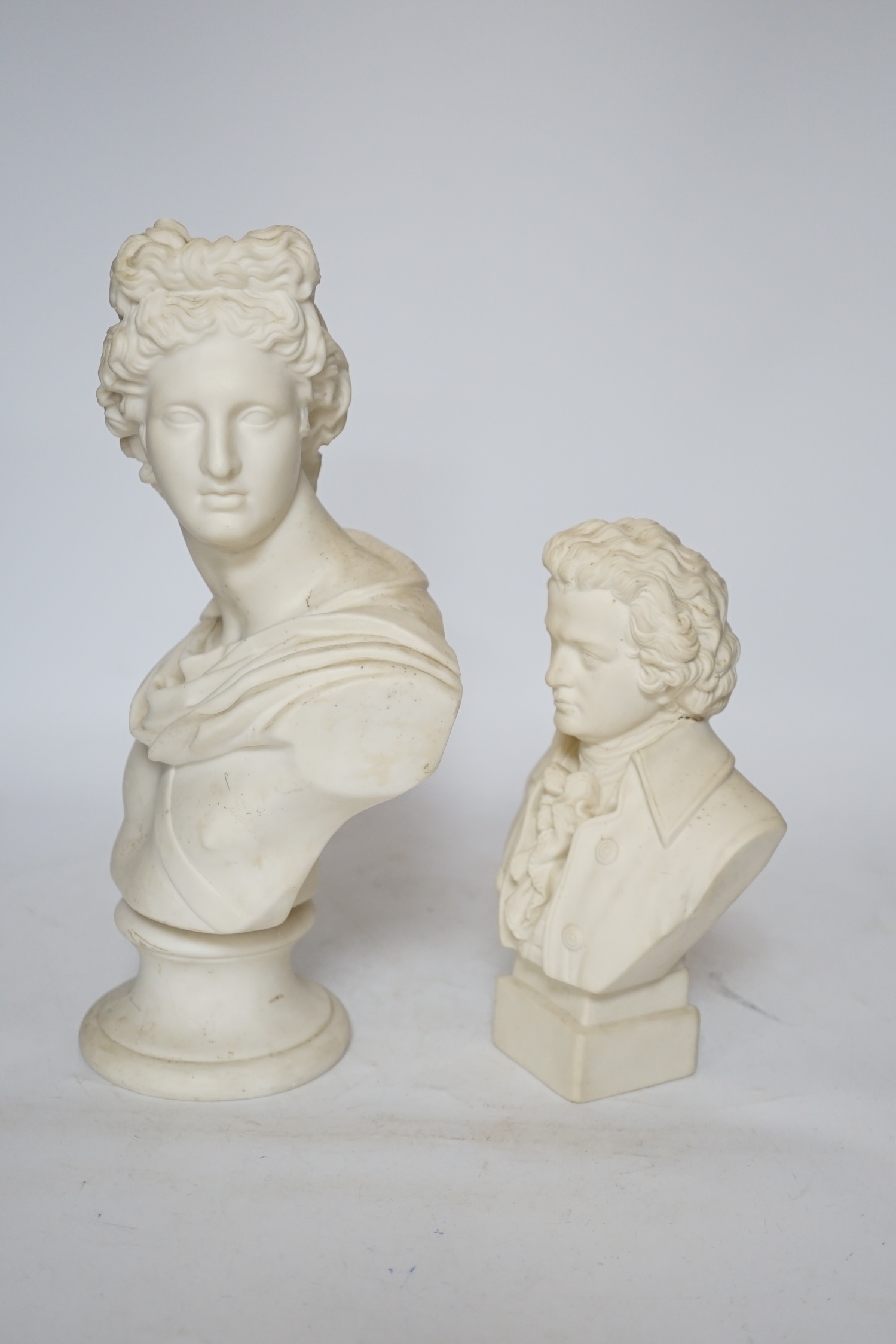 Two Continental biscuit porcelain busts, Mozart and Apollo, tallest 29cm